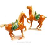 A pair of Chinese Tang style ceramic horses; each approximately 26cm high.