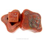 A Chinese, deep red, carved, soapstone box containing a soapstone seal within