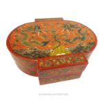 A Chinese, wooden and red lacquered box adorned with dragons