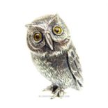 A sterling silver owl figurine with orange glass eyes