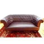 A large, brown, leatherette, Chesterfield sofa