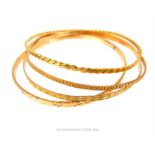 Four, 18 ct yellow gold, textured/engraved bangles