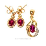 A boxed, 9 ct yellow gold garnet set pendant and drop stud earrings set.