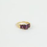 A 14 ct yellow gold and stepped-cut, graduated, 3-stone, garnet ring