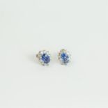 A boxed pair of 18 ct white gold, sapphire and diamond cluster earrings
