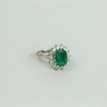 An 18 ct white gold, emerald and diamond cluster ring