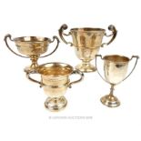 A collection of four sterling silver twin handled trophy cups