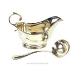 A sterling silver sauce boat and sauce ladle