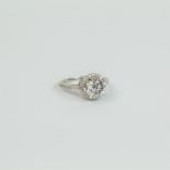 An 18 ct white gold and diamond solitaire, cluster ring (3.1 carats)