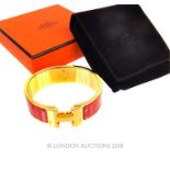 A boxed, Hermes, gold plated 'Clic Clac H' bangle with red enamel detail