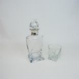 A crystal decanter with a sterling silver collar and matching glass