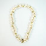 A fine, 18 ct yellow gold and double-strand, baroque pearl necklace