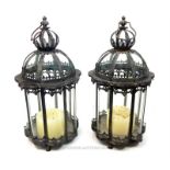 A pair of distressed metal storm lanterns