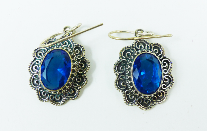 A pair of large, sterling silver and faceted blue stone earrings