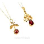 Two, boxed, 9 ct yellow gold and garnet pendants on gold chains