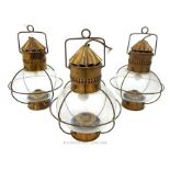 A set of three spherical glass lanterns with brass mounts