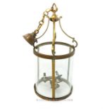 A cylindrical brass hanging storm lantern