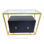 A contemporary sideboard with cupboard to its base surrounded by a gilt metal frame with a glass