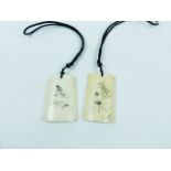 A pair of Chinese bone pendants with erotic detail