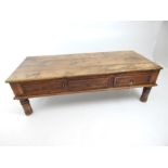 An rustic Indian style, teak coffee table; 131 cm wide.
