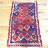 An antique, Kazak rug decorated with a colourful, tile motif design