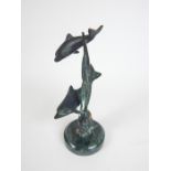 A verdigris bronze group of two dolphins
