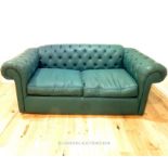 A dark green leatherette, Chesterfield-style sofa bed