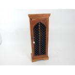 A small acacia style, CD cupboard with cast iron grille to its door; 86cm high.