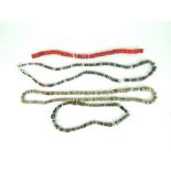 A coral necklace dyed red together with three Bedouin glass bead and metal necklaces. (4)