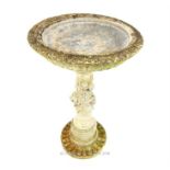 An attractive, composite-stone birdbath on a pedestal base