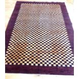 A large, woollen, Afghan rug with a chocolate-brown, checker-board design