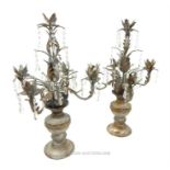 A pair of distressed metal, candelabras with glass drops; 68cm high.