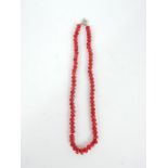 A beaded red faceted hardstone necklace with a white metal clasp