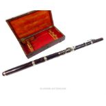 A late 19th/ early 20th century Adler, simple system, rosewood flute with white metal fittings and a