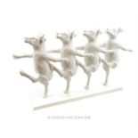 A 20th century composite figural group of marching cows; 33.5cm long.