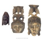 Two large tribal wall hanging masks together with a smaller mask; largest 64cm long.