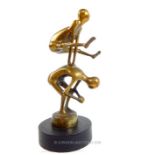 A bronze figure of one man jumping over another