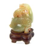 A Chinese, carved, green jade, mythical beast on stand