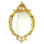 An oval gilt framed mirror in the Rococo style