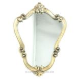 An ornate, mirror with carved, silvered frame