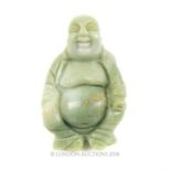 A Chinese, carved, pale green, jade Buddha