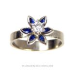 A white gold flower ring set with sapphires and diamond