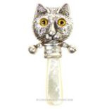 A silver baby's rattle with mother of pearl handle and cat's face finial