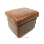 A contemporary, brown leather stool with wooden bun feet