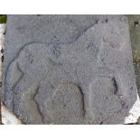 A weathered stone plaque carved with a depiction of a horse