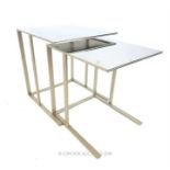 A nest of two B&B Italia style tables with chrome tops and white metal frames; largest 46cm wide and