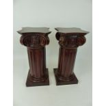 A pair of mahogany ionic column stands