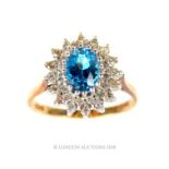 A EDWARDIAN 9CT GOLD, AQUAMARINE AND DIAMOND CLUSTER RING. Having an oval cut aquamarine stone