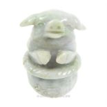 A Chinese, carved green jade carving depicting a pig in a basket