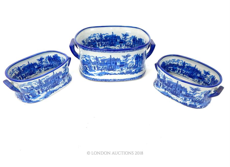 A set of three blue and white foot baths